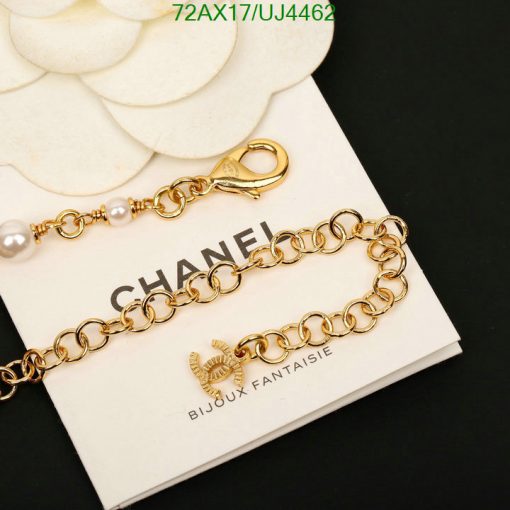 Gold bracelet with pearls on white background.