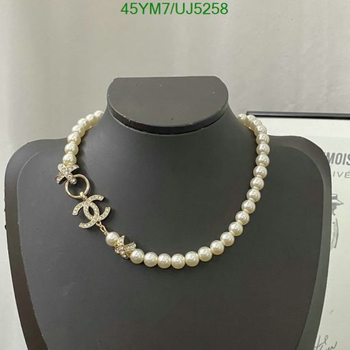 Pearl necklace with diamond pendant on display mannequin.