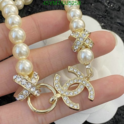 Pearl necklace with gold and rhinestone clasp.