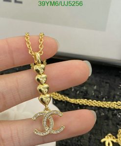 Gold heart chain with sparkly pendant held by fingers.