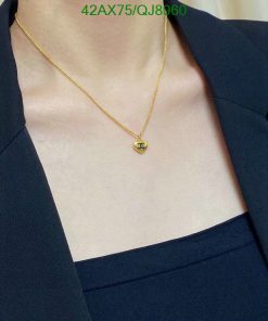 Gold necklace on person with navy blazer.