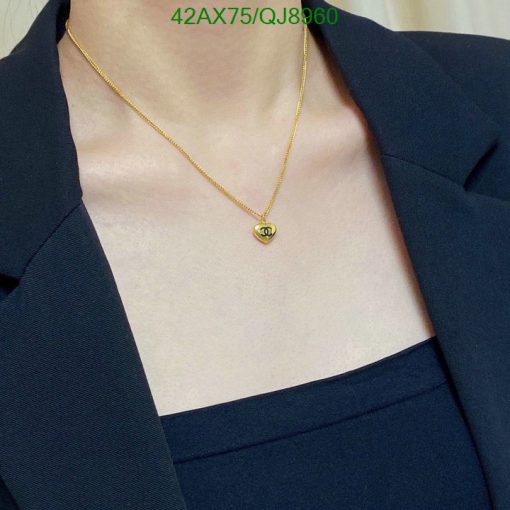 Gold necklace on person with navy blazer.