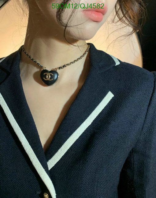 Woman wearing necklace with heart-shaped pendant.