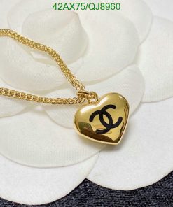 Gold heart pendant necklace on white flower.