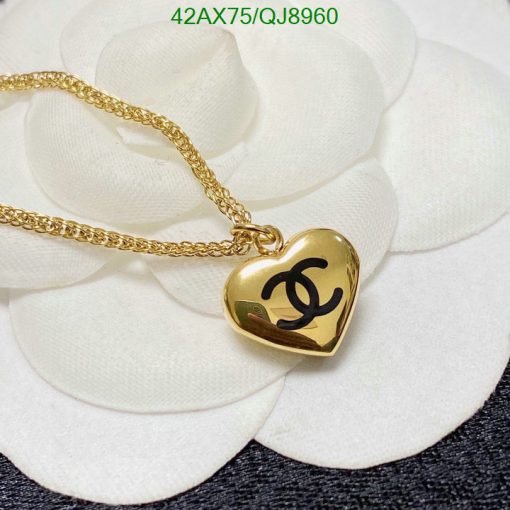 Gold heart pendant necklace on white flower.