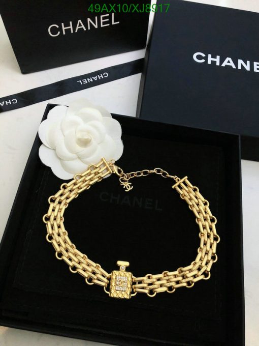 Gold chain bracelet on designer packaging with white flower