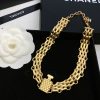 Gold Chanel perfume bottle-shaped necklace with packaging.