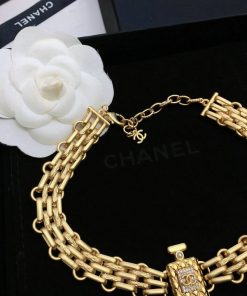 Designer gold-tone chain belt with white flower.