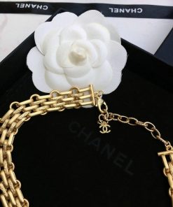 Designer gold chain necklace with white camellia flower.