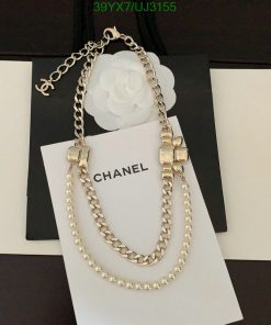 Gold chain necklace with pearls on branded card.