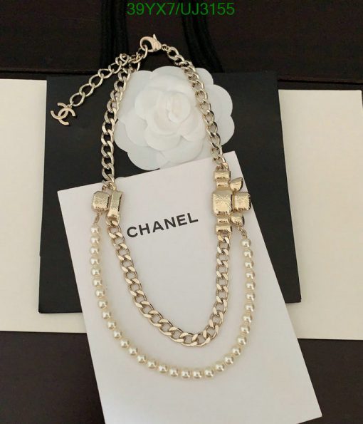 Gold chain necklace with pearls on branded card.