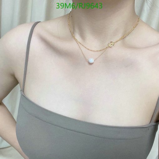 Person wearing necklace with pearl pendant.