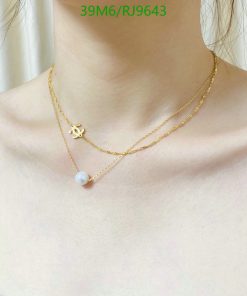 Layered gold necklaces with pendant on woman's neck.