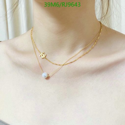 Layered gold necklaces with pendant on woman's neck.