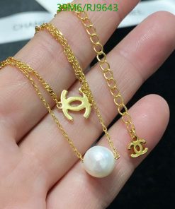 Gold bracelets with charm and pearl detail.