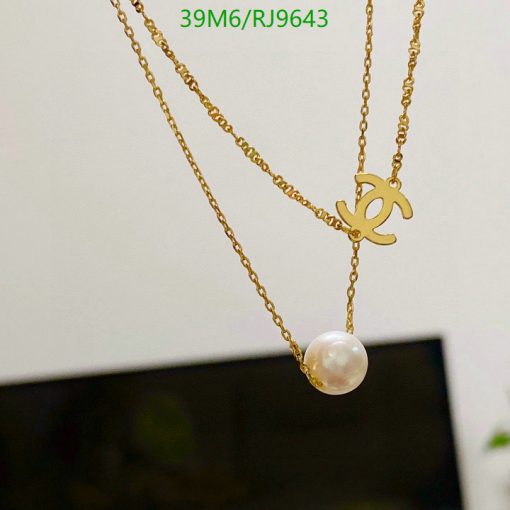 Gold chain necklace with pearl pendant.