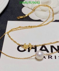 Gold necklace with pearl pendant on branded card.