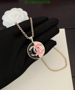 Elegant circular pendant necklace on black glove.