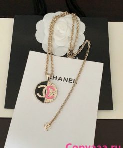 Chanel logo pendant necklace on white display.