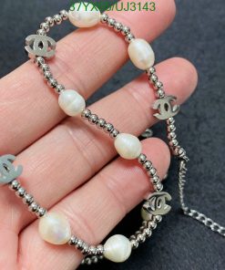 Pearl bracelet with silver designer logo charms.