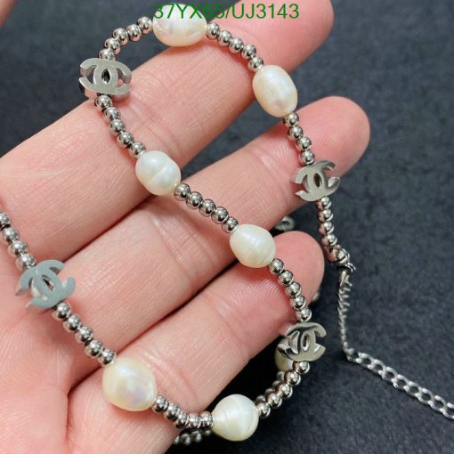 Pearl bracelet with silver designer logo charms.