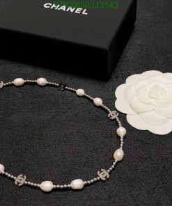 Elegant pearl necklace with branded accents on dark surface.