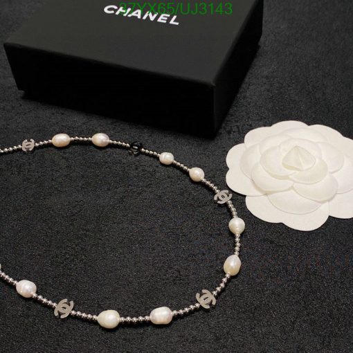 Elegant pearl necklace with branded accents on dark surface.