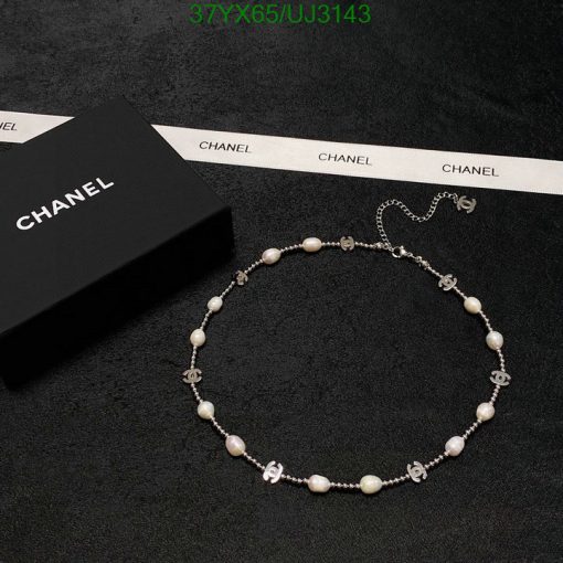 Chanel pearl necklace with logo on black background