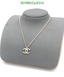 Gold pendant necklace on gray display stand.