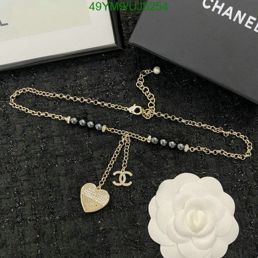 Gold chain necklace with heart pendant and pearl accents.