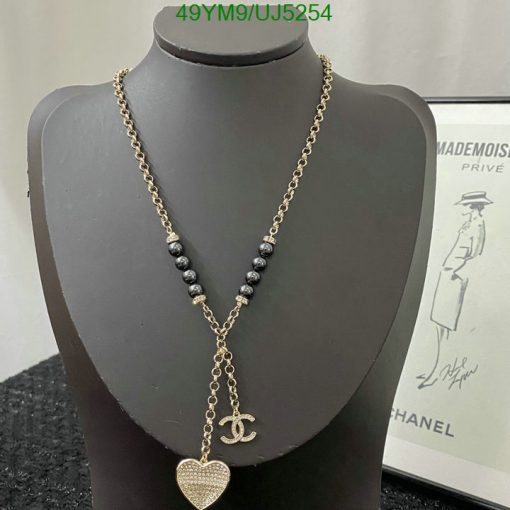 Gold chain necklace with heart pendant on mannequin.