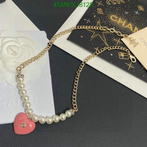 Gold chain pearl bracelet with heart charm on designer stationery.