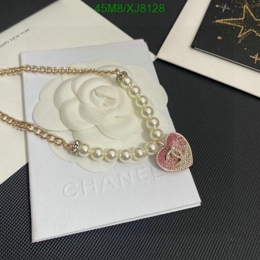 Pearl necklace with heart pendant on white floral backdrop.