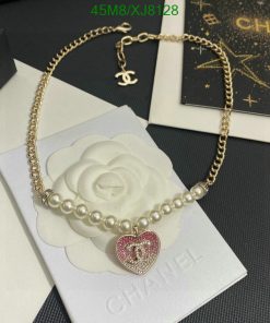 Designer pearl necklace with heart pendant on display.