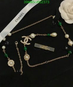 Designer pearl and gemstone jewelry on black surface.