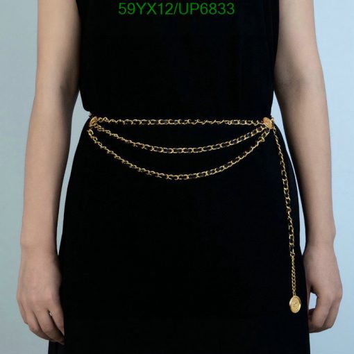 Woman in black dress with gold chain belt.