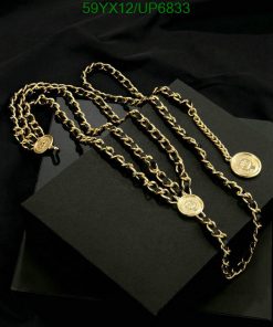 Gold chain necklaces on black backdrop.