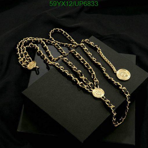 Gold chain necklaces on black backdrop.