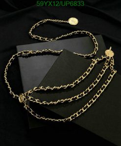 Gold chain necklace on black velvet with books.