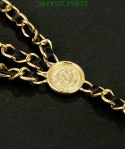 Gold chain with medallion on black background.