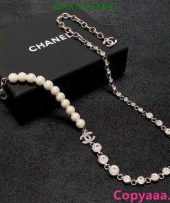 Elegant pearl and chain necklace on black background.