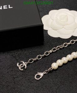 Chanel branded pearl bracelet near box and flower logo.