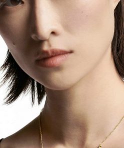 Woman model showcasing delicate gold necklace.