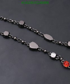 Black chain necklace with solitary red gemstone.