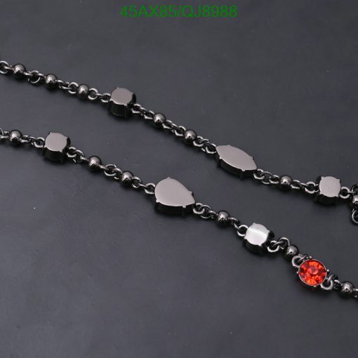 Black chain necklace with solitary red gemstone.