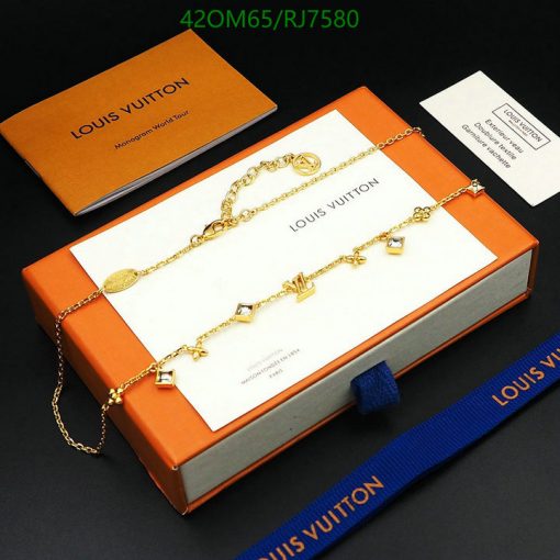 Gold Louis Vuitton charm bracelet with packaging.