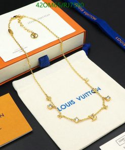 Designer gold-tone necklace on branded display packaging.