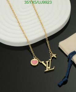 Gold pendant necklace with heart and initials on display.