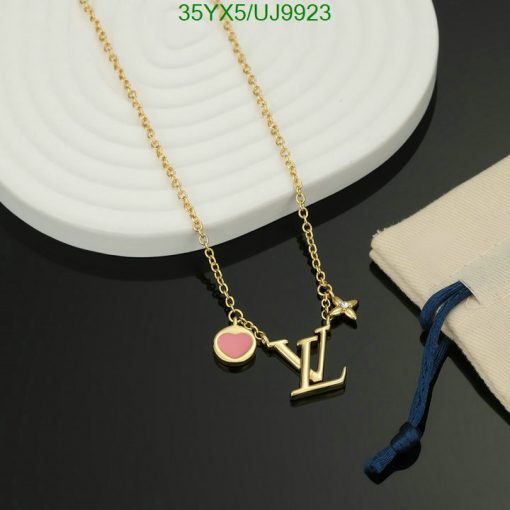 Gold pendant necklace with heart and initials on display.