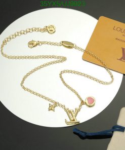 Designer gold-tone charm necklace with brand card.